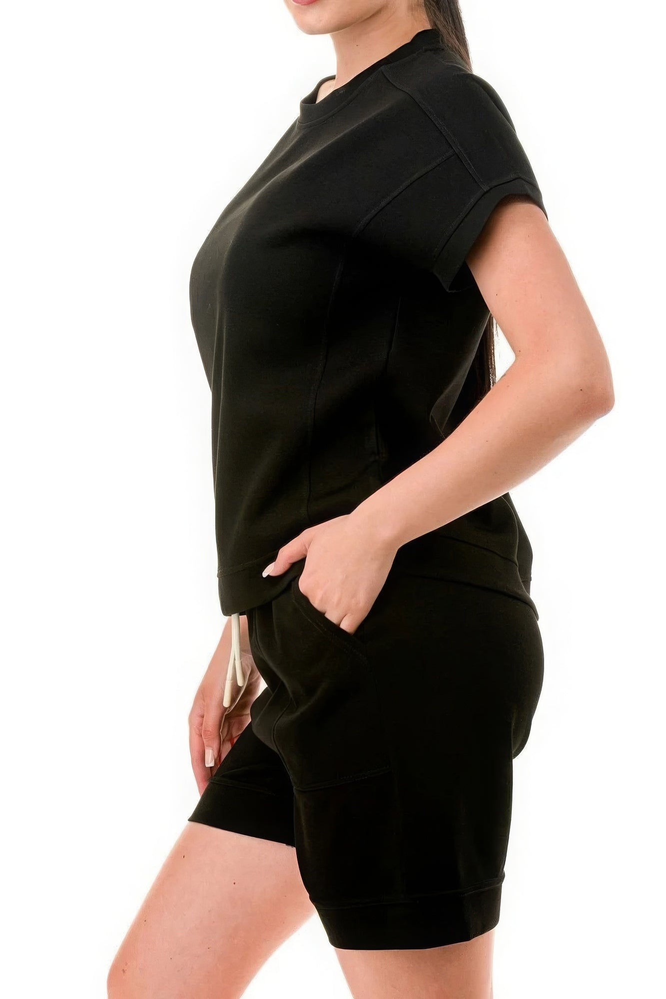 Woman wearing a black monochrome tee and shorts set made of lightweight air cotton, showcasing relaxed, comfortable fit.