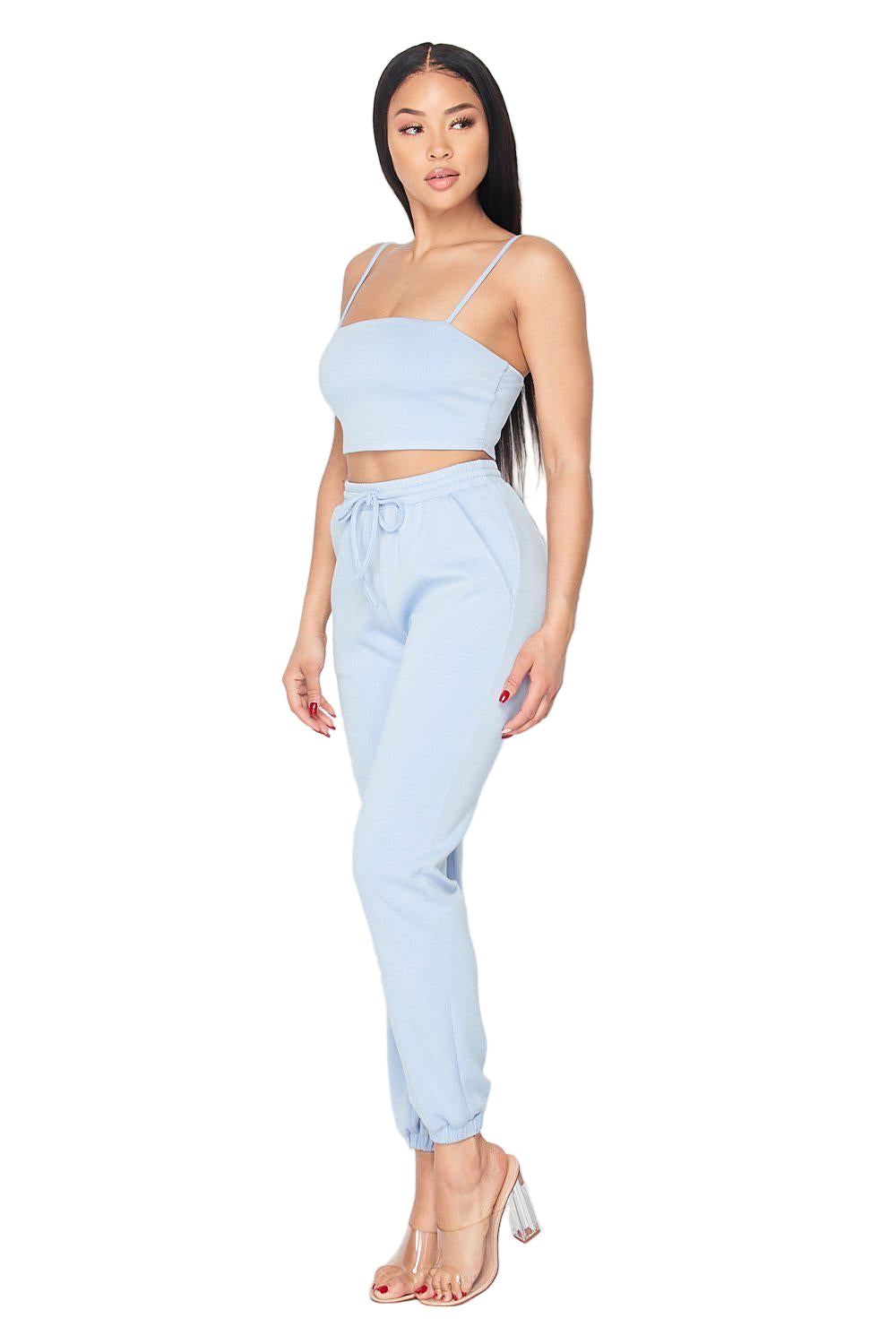 "Woman wearing Keep It Cute Two-Piece Set in light blue, featuring a crop top and jogger pants, made of rayon, polyester, and spandex."