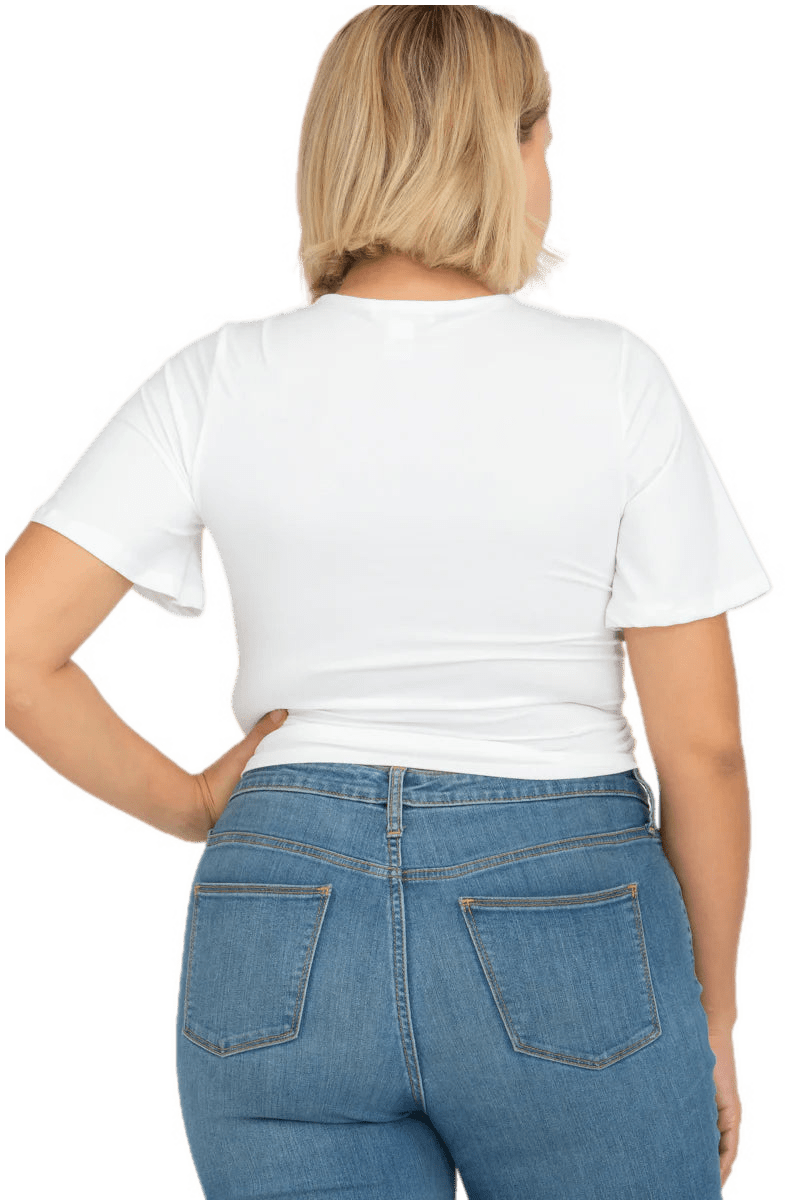 Plus size model wearing a white strap front short sleeve crop top with ruched detailing, paired with blue jeans, showcasing the back view.