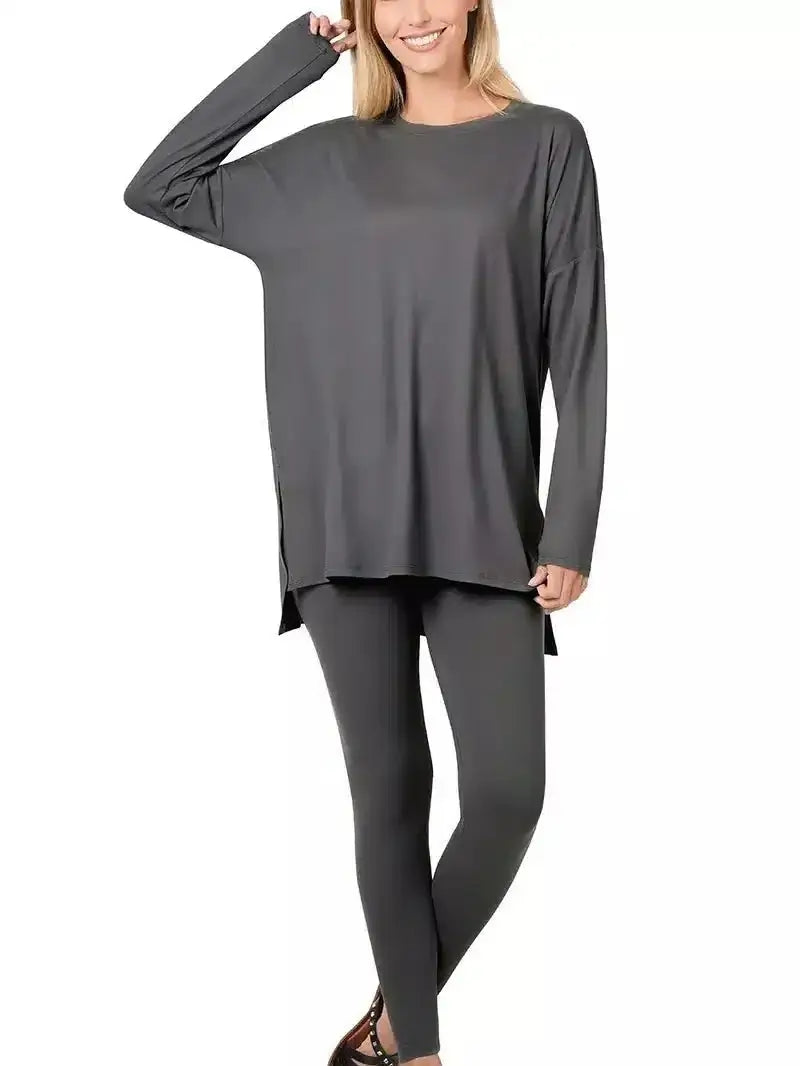 "Woman wearing cozy gray loungewear set with oversized top and leggings, perfect for relaxing or running errands."