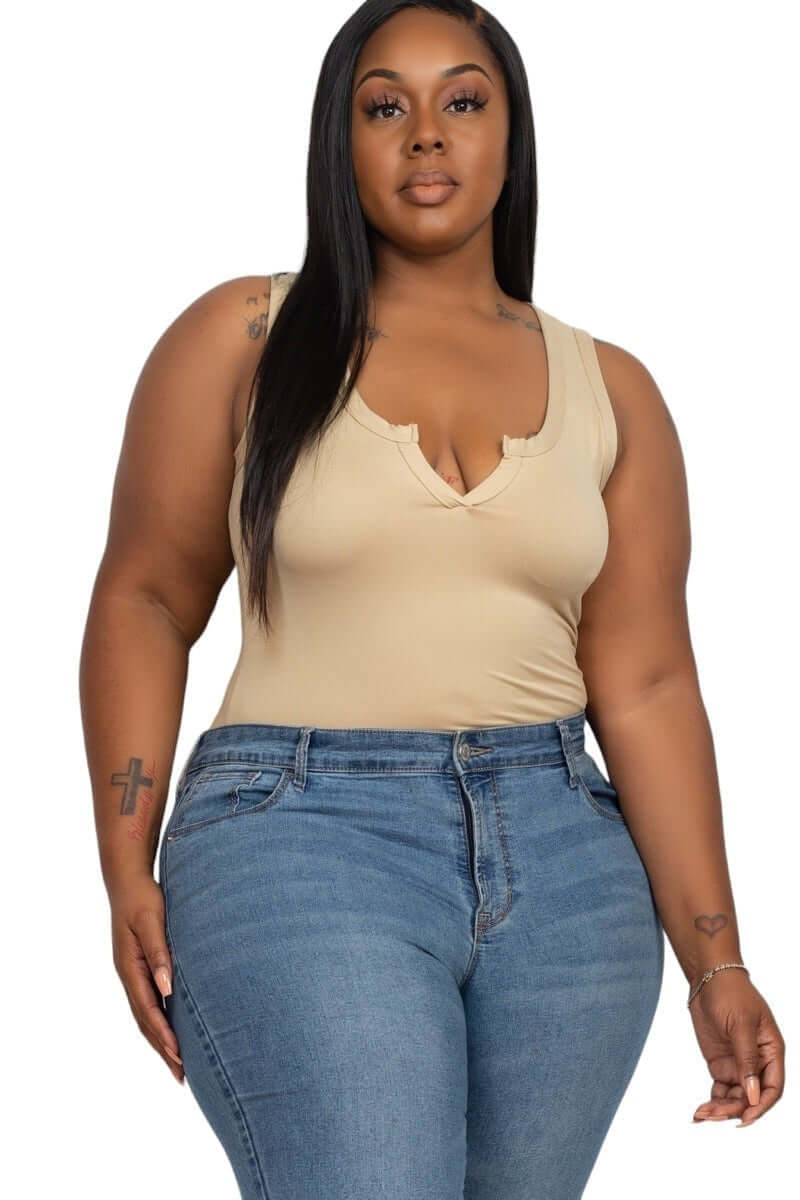 Plus size woman wearing a beige curvy bodysuit and blue jeans, showcasing a confident and stylish look.