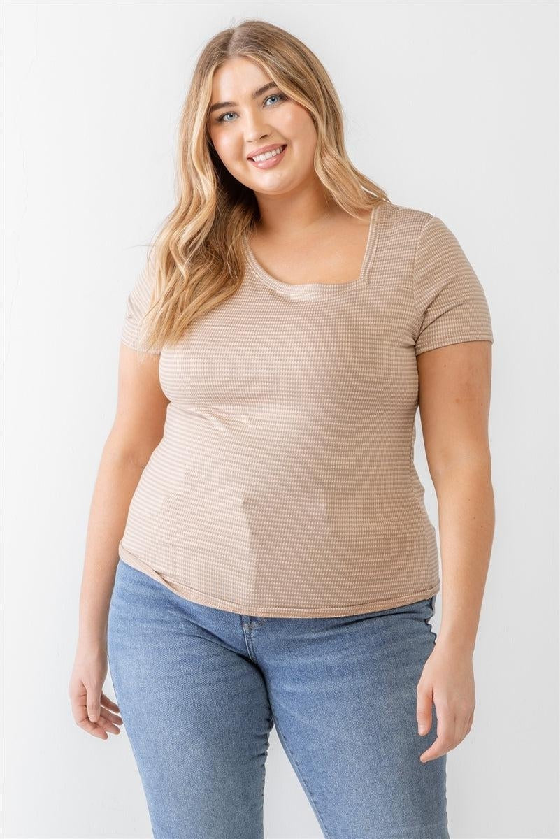 Plus size woman in striped short sleeve top and jeans, smiling confidently.