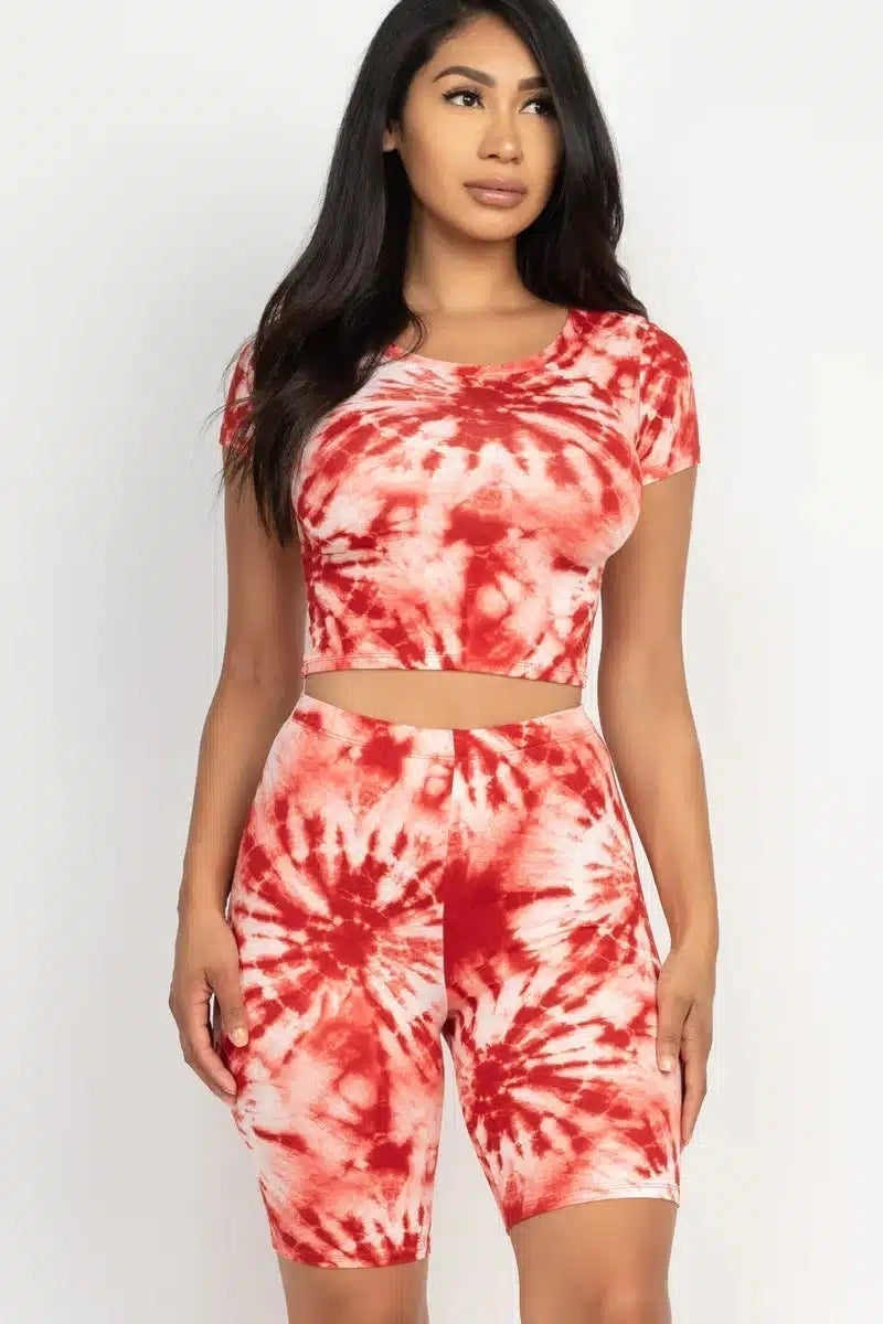 Woman in red tie-dye crop top and shorts, showcasing latest women's fashion trends.