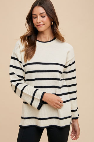 Ivory side slit striped round neck sweater with black stripes, no stretch, ribbed, 40% acrylic, 30% polyester, and 30% nylon.