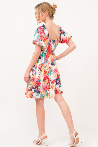 Multicolor square neck puff sleeve floral dress with ruched design and pockets, made of opaque polyester, showcasing vibrant style.