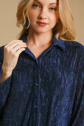 Woman wearing navy side slit texture button-up shirt made of polyester and spandex, showcasing buttoned and slightly stretchy design.