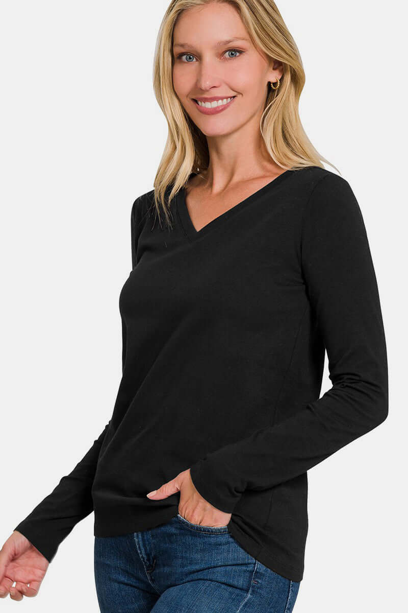 Woman wearing a black full-size V-neck long sleeve t-shirt made of 95% cotton and 5% spandex, paired with jeans.