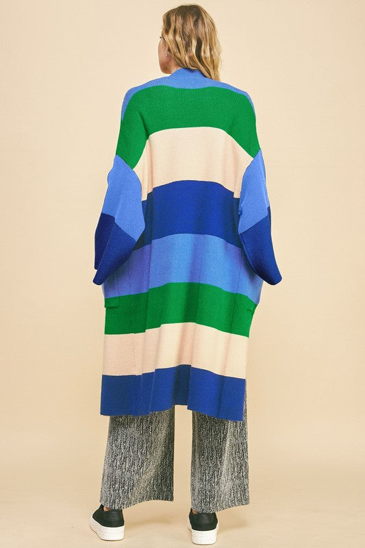 Woman wearing blue stripe color block kimono sleeve cardigan with pockets, composed of viscose, polyester, and nylon.