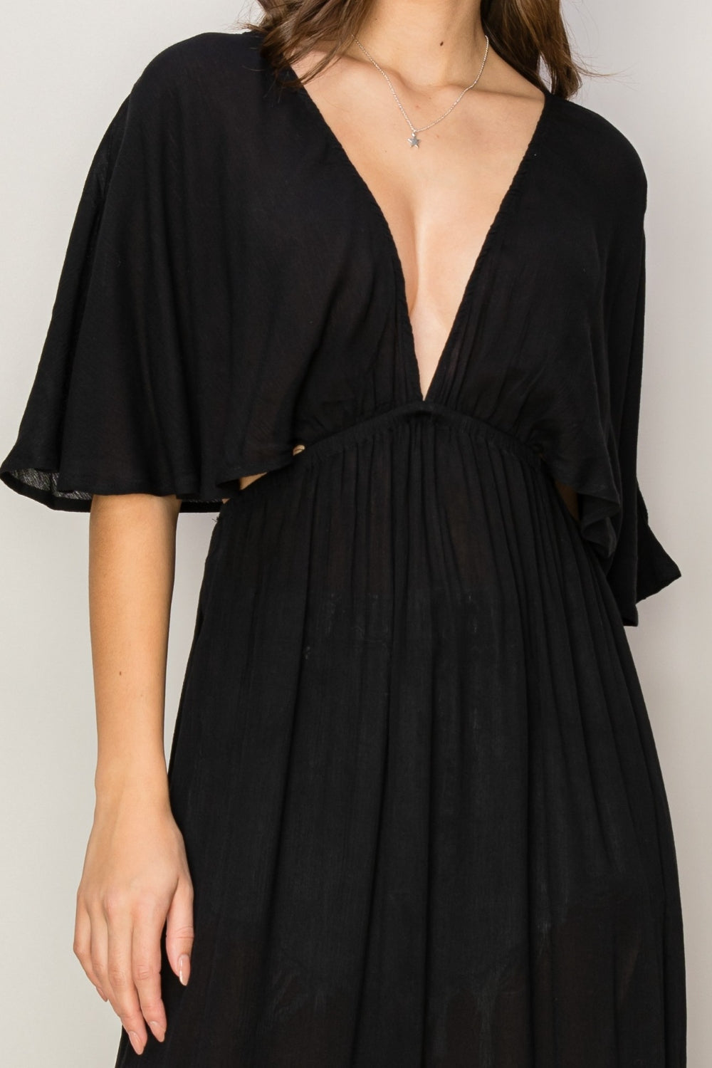 Elegant black tie back maxi split dress with ruffled sleeves, backless design, and deep V-neckline made of 100% rayon.