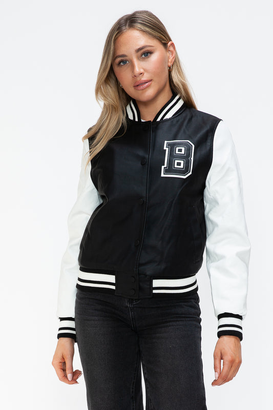 Woman wearing a Love PU Leather Contrast Snap Down Bomber Jacket with black and white design featuring a letter patch on the chest.