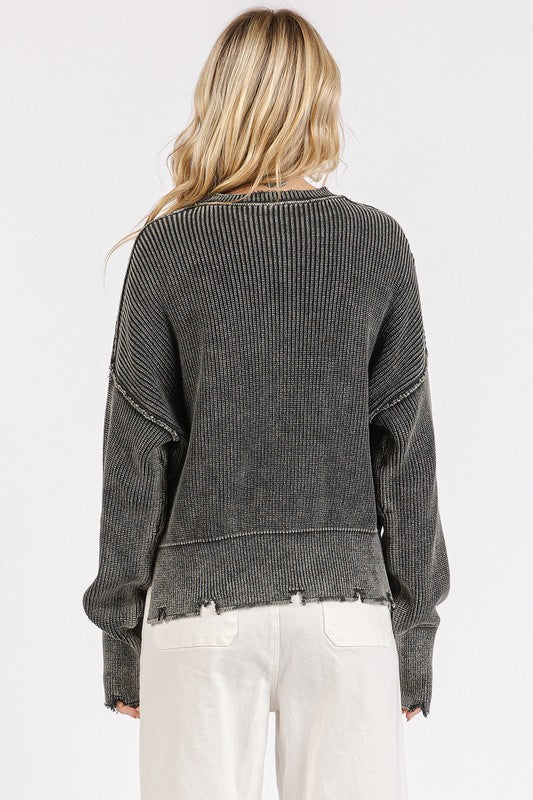 Dark gray round neck sweater with exposed seams, washed finish, and slit distressed hem, worn by a model.