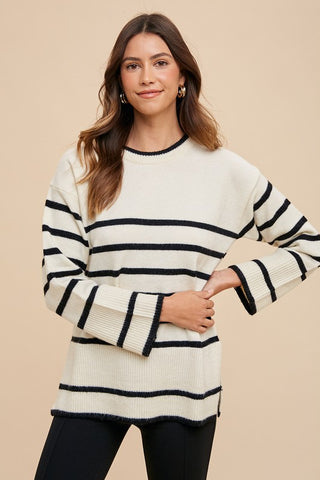 Ivory side slit striped round neck sweater with black stripes, worn by a model, showcasing a basic ribbed style.