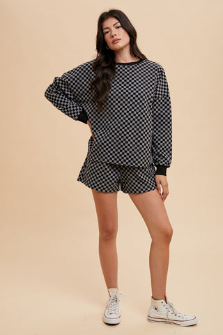 Black checkered round neck top and drawstring shorts set with pockets, slightly stretchy polyester-spandex blend, casual two-piece outfit.