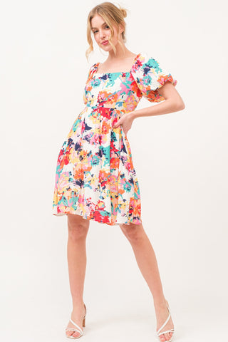 Multicolor floral dress with square neck and puff sleeves, featuring a ruched, pocketed design made of 100% polyester.