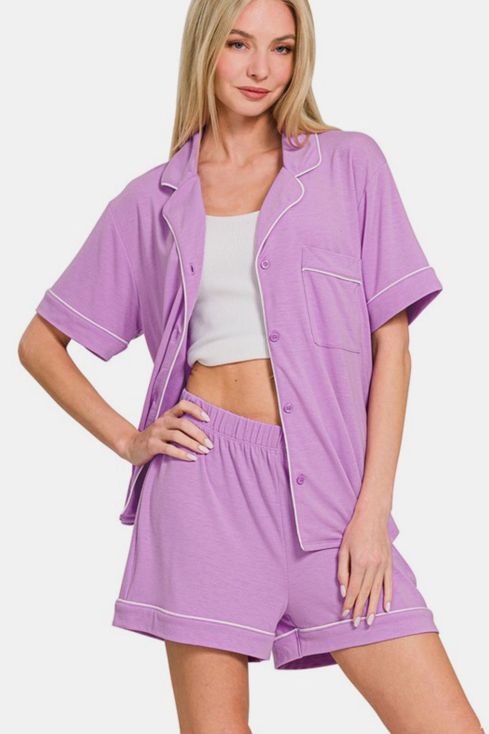 Woman wearing a purple button-down short sleeve top and shorts lounge set with pockets, showcasing a casual and comfortable style.