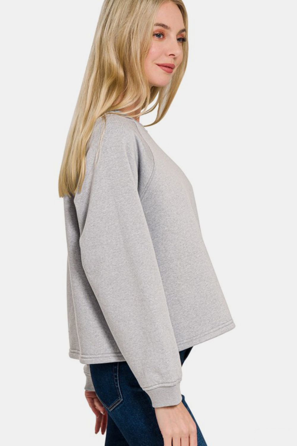 Woman wearing gray round neck raglan sleeve top from two-piece set with pocketed design and slightly stretchy cotton blend material.