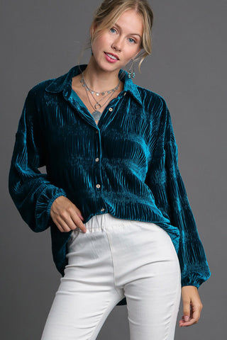 Woman modeling teal ruched tiered button-up shirt with slightly stretchy polyester-spandex fabric.