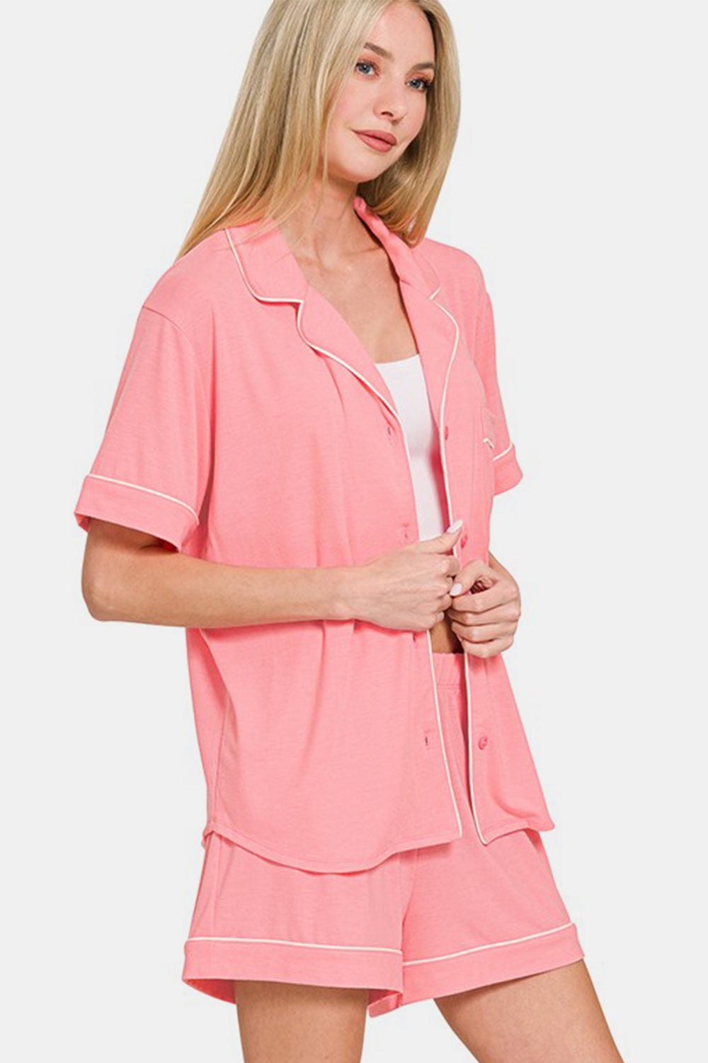 Woman wearing a dark pink button down short sleeve top and shorts lounge set with buttons and pockets, made of polyester, rayon, and spandex.