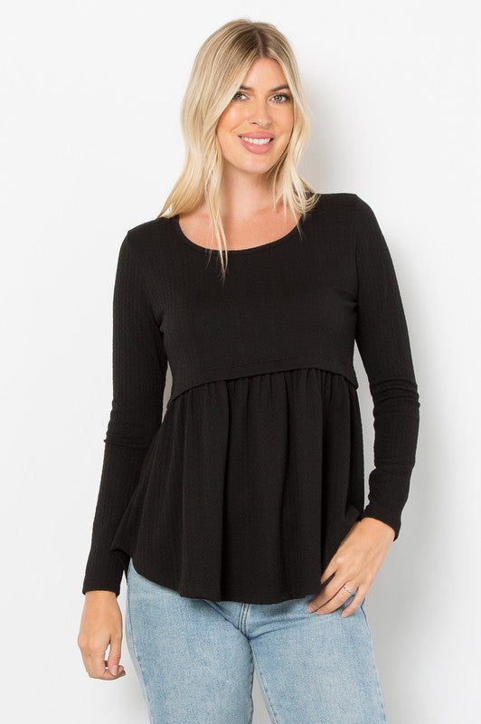 Black full-size knit top with round neck and long sleeves, featuring cable-knit peplum style, worn by model with light hair.