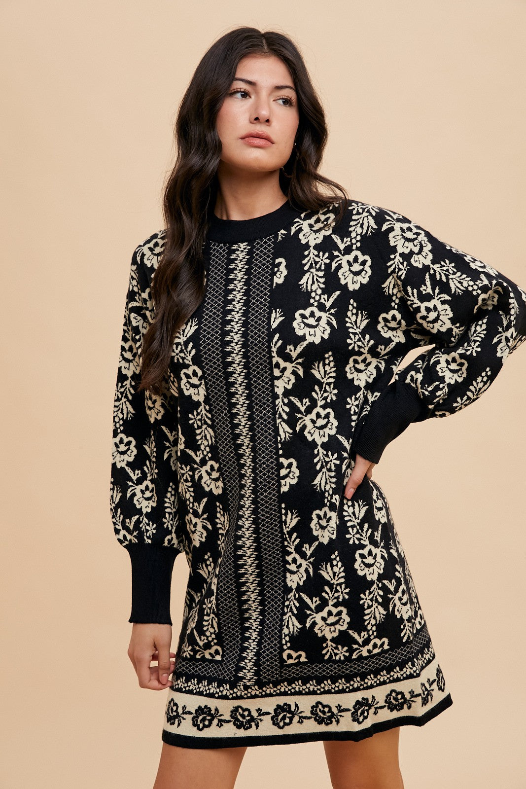 Woman wearing Faith Floral Jacquard Round Neck Sweater Dress with black and white floral design, slightly stretchy fabric.