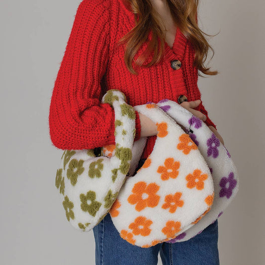 Woman holding floral pattern sherpa bags in green, orange, and purple, perfect for fall or winter. Made of 100% polyester.