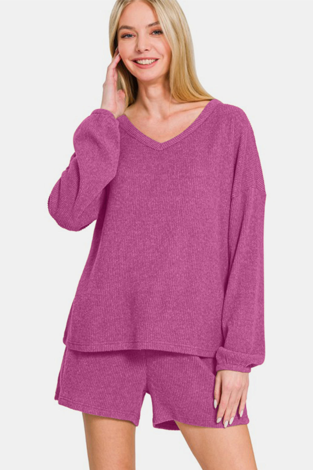 Woman wearing Zenana V-Neck Long Sleeve Ribbed Top and Shorts Set in purple, showcasing stylish and comfortable casual outfit.