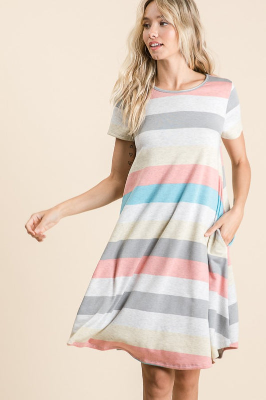 Woman wearing a multicolor striped short sleeve dress with pockets, featuring a basic style in slightly stretchy polyester blend.