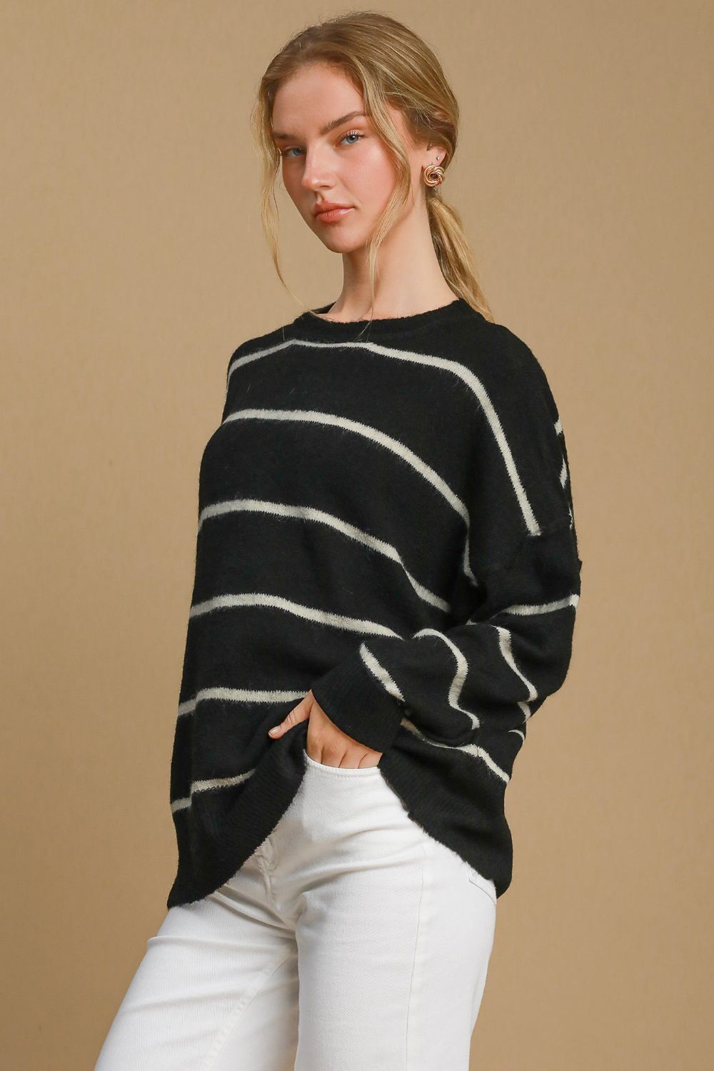 Woman wearing a wool blend striped round neck sweater with ribbed detailing and a relaxed fit, made from polyester, acrylic, nylon, and wool.