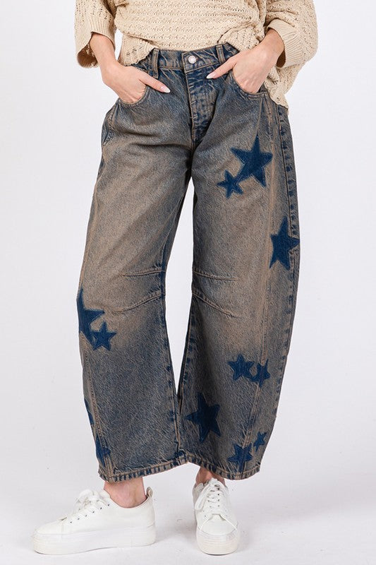 Wide leg jeans with star pattern and pockets made from 100% cotton, slightly stretchy fabric, styled with white sneakers.