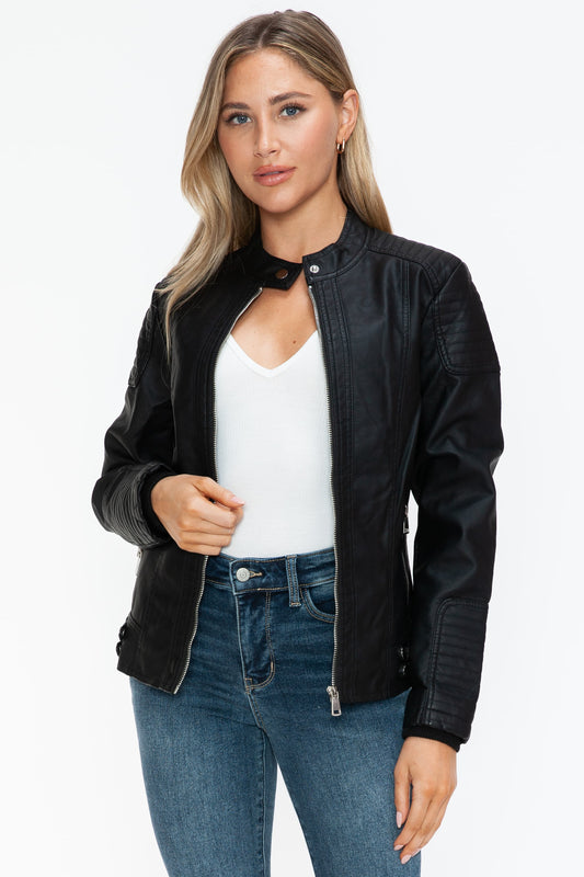 Stylish woman wearing a Snobbish faux leather biker jacket with side zip pockets and a white top.