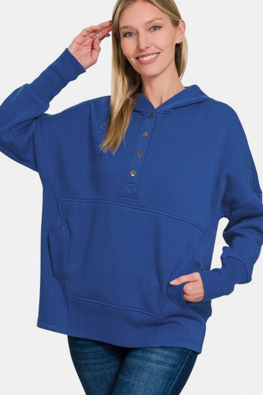 Woman wearing a navy half snap long sleeve hoodie with kangaroo pocket, showcasing a casual and comfortable style.