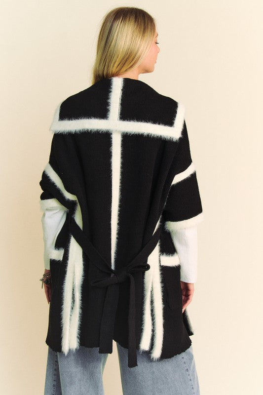 Woman wearing Davi & Dani fuzzy trim open front loose fit cardigan with tied back, featuring black and white design.