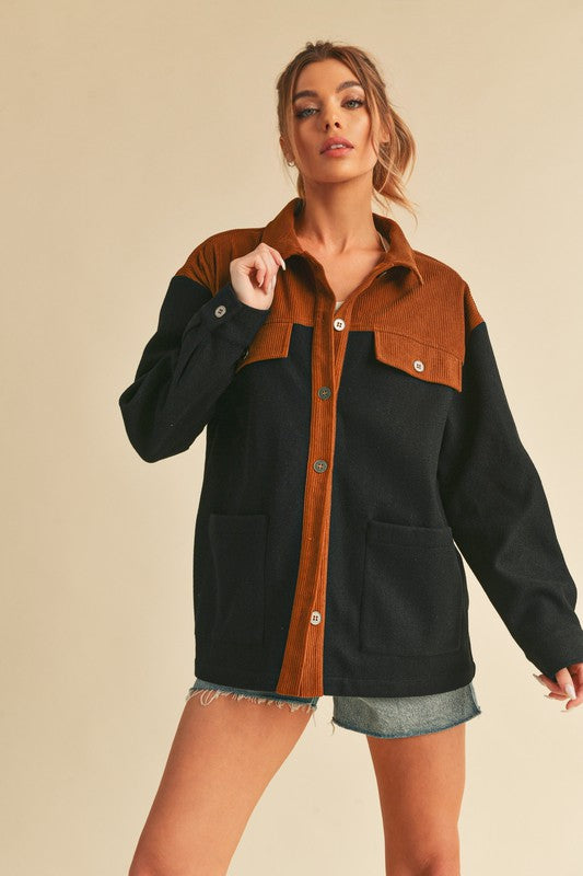 Woman wearing dark navy two-tone button up jacket with pockets, ribbed detail, and casual style.