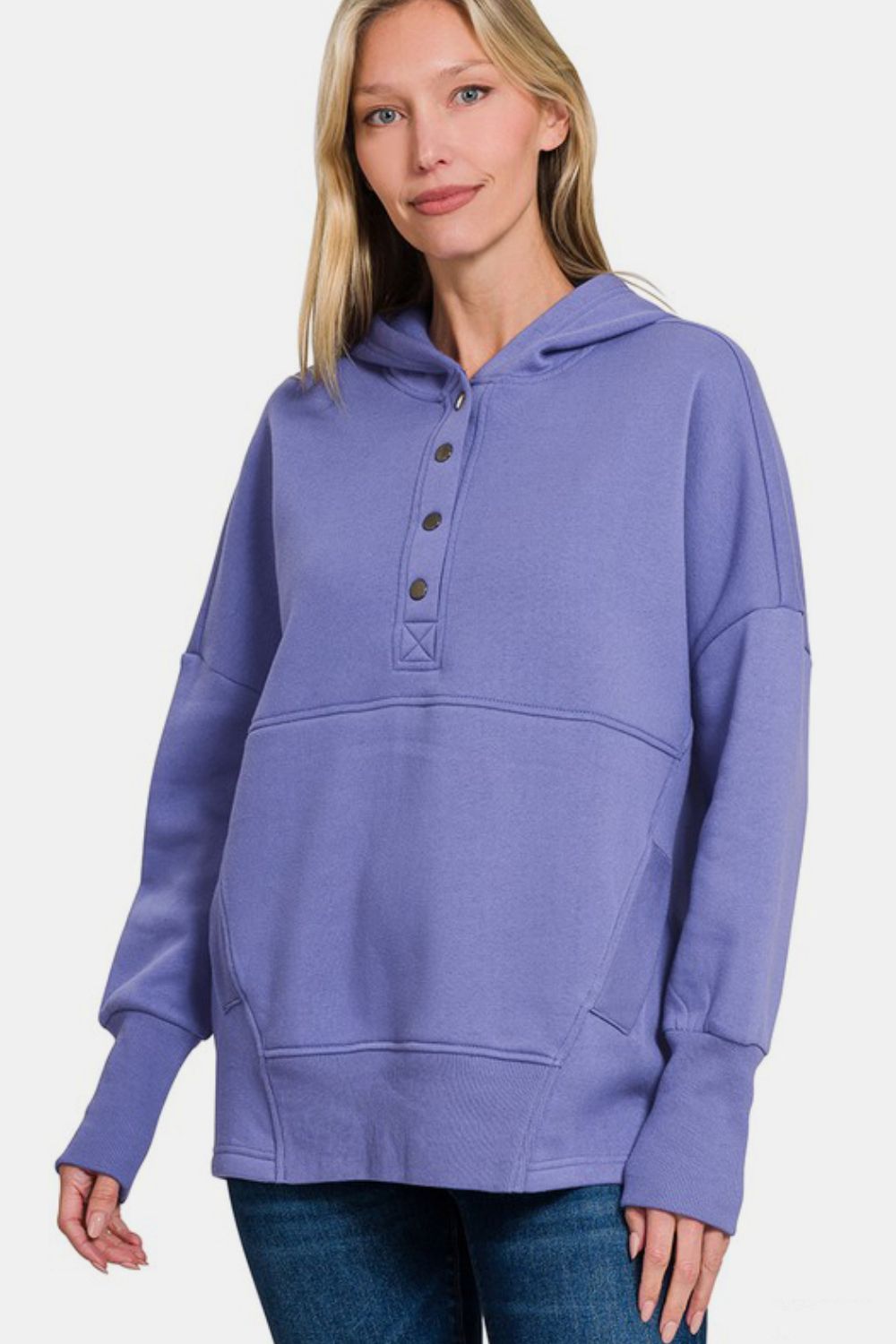 Woman wearing Zenana half snap long sleeve hoodie with kangaroo pocket in purple, showcasing sporty and comfortable fashion.