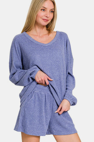 Woman wearing Zenana V-Neck Long Sleeve Ribbed Top and Shorts Set, showcasing casual chic style in blue textured fabric.