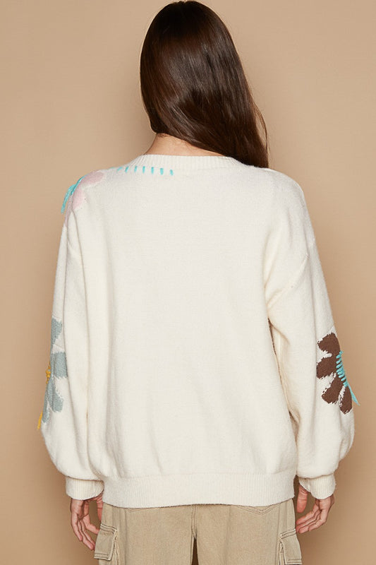 Back view of ivory V-neck long sleeve sweater with flower fringe details, worn by model.