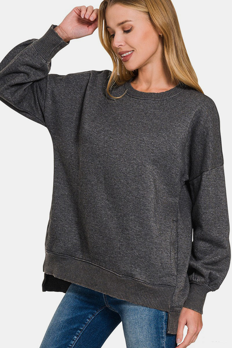 Woman wearing Zenana High-Low Acid Wash Fleece Sweatshirt in dark gray with trendy high-low hemline and vintage style.