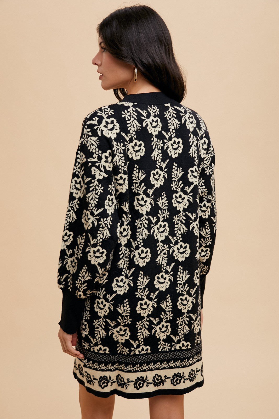 Woman wearing Faith Floral Jacquard Round Neck Sweater Dress in black with elegant floral design, slightly stretchy knit fabric.