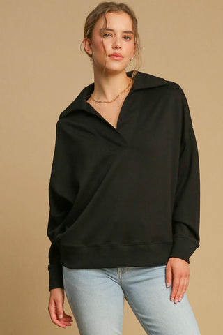 Woman wearing a black Johnny collar dropped shoulder sweatshirt, featuring a basic style and slightly stretchy fabric.