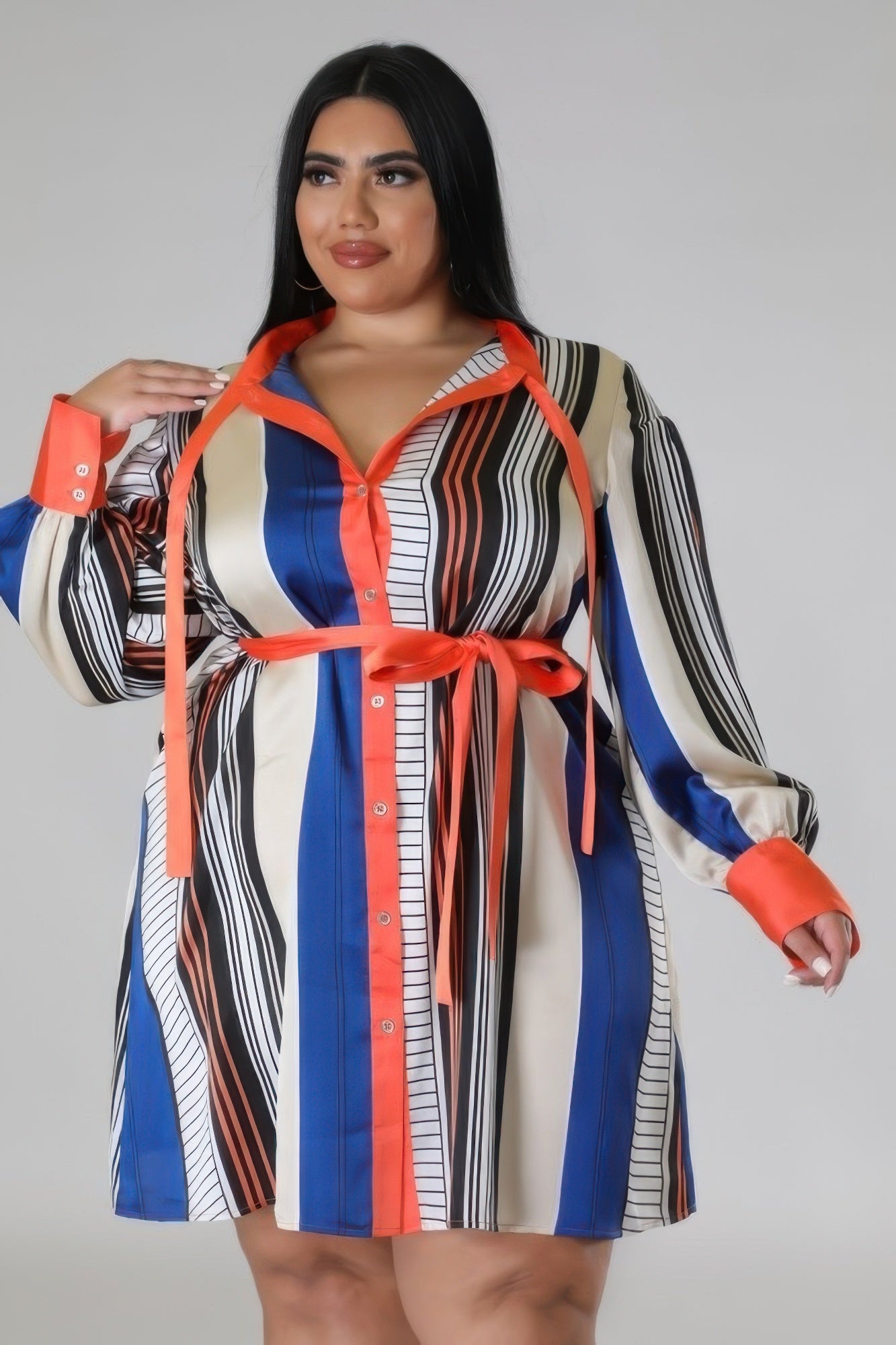 Plus-size model in a colorful striped button-up long sleeve dress with waist tie, showcasing elegant and chic fashion style.