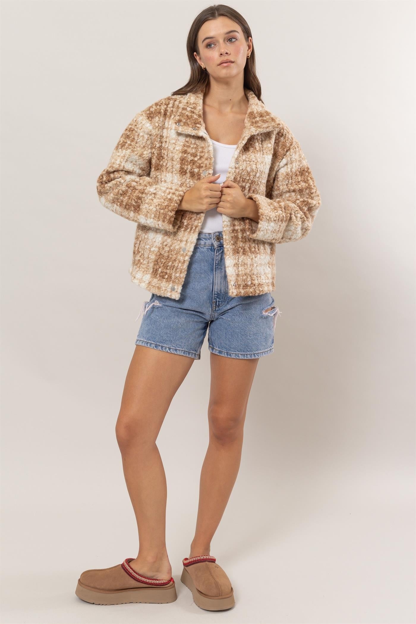 Taupe plaid boucle jacket with collared neck and pockets, worn over a white top and denim shorts.