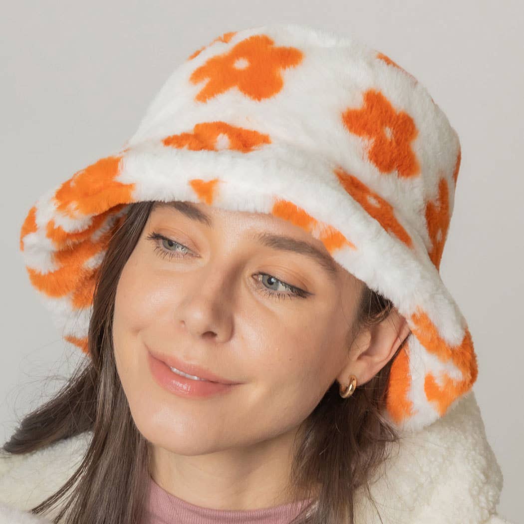 Woman wearing floral printed faux fur bucket hat with orange flowers, cozy winter accessory with adjustable strings.