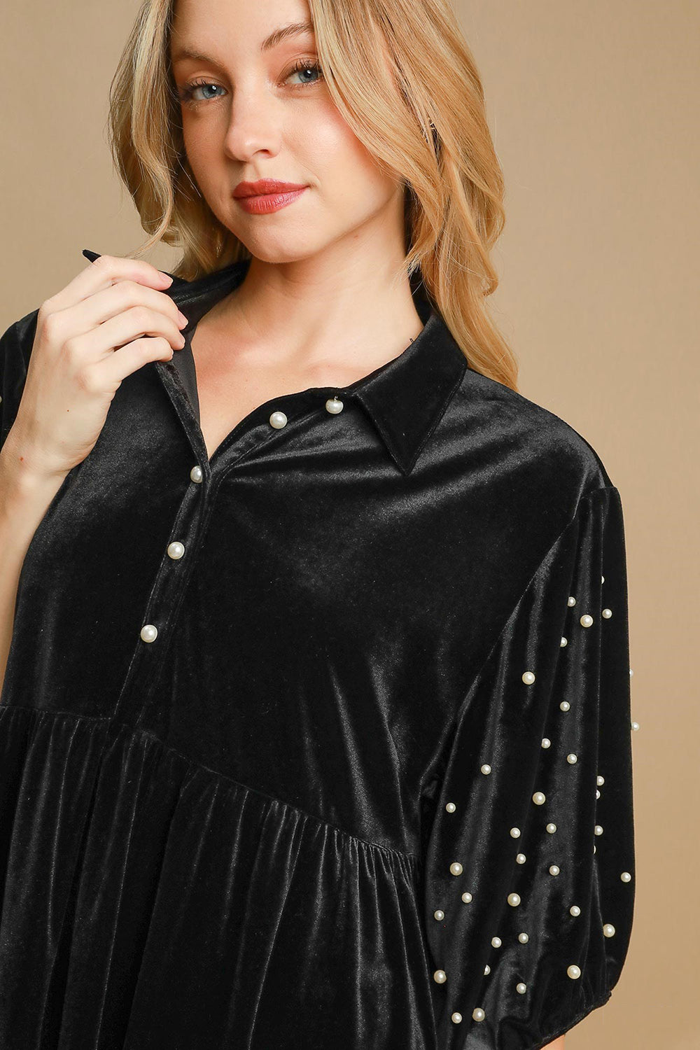 Black pearl detail velvet blouse with half sleeves and buttoned front worn by a woman.