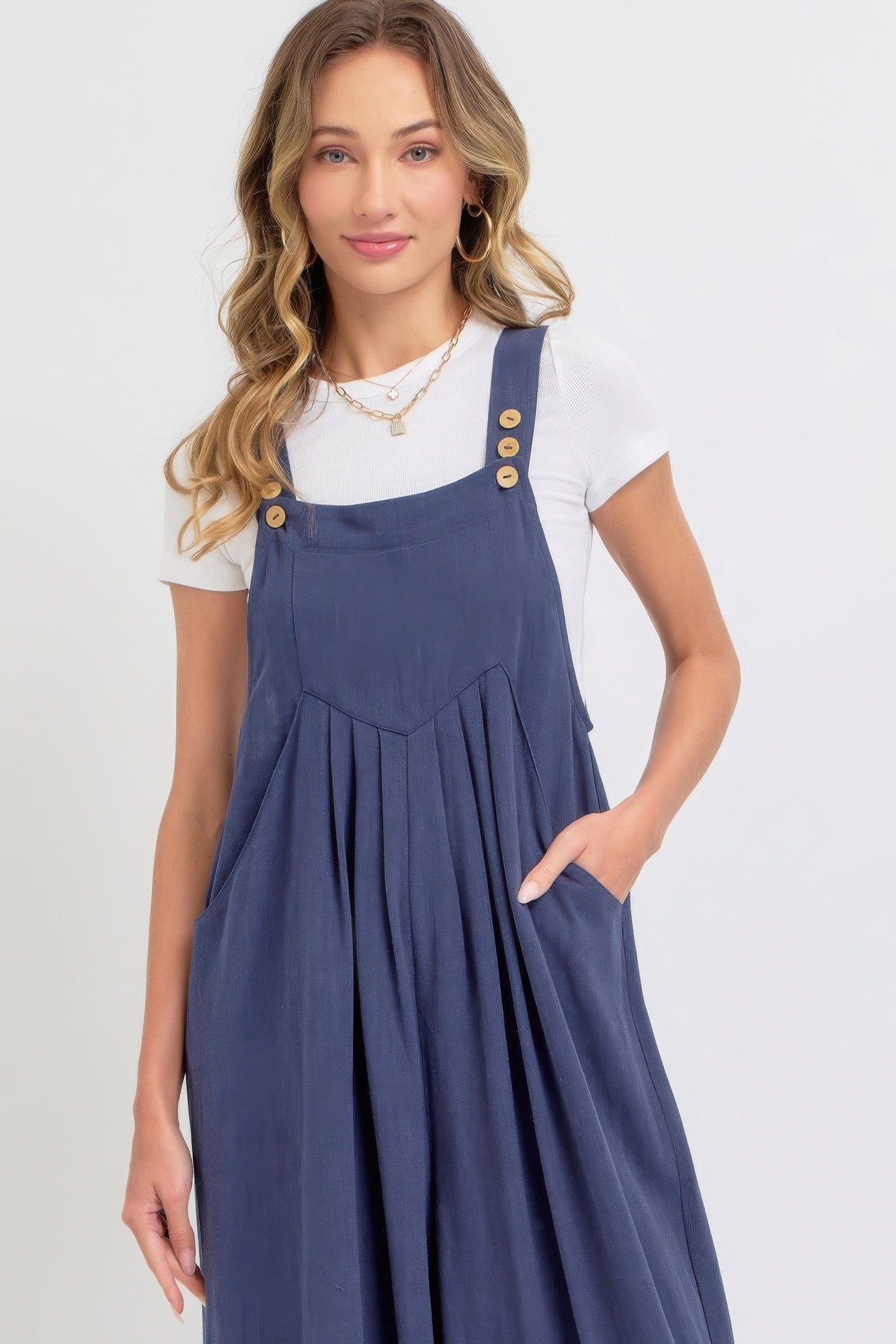 Woman wearing a chic adjustable strap overall wide leg jumpsuit in solid blue, lightweight and perfect for casual or sophisticated looks.