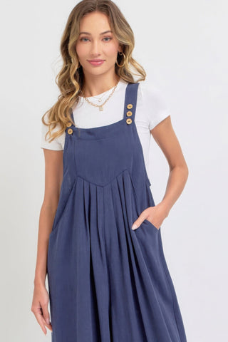 Woman wearing a chic adjustable strap overall wide leg jumpsuit in solid blue, lightweight and perfect for casual or sophisticated looks.