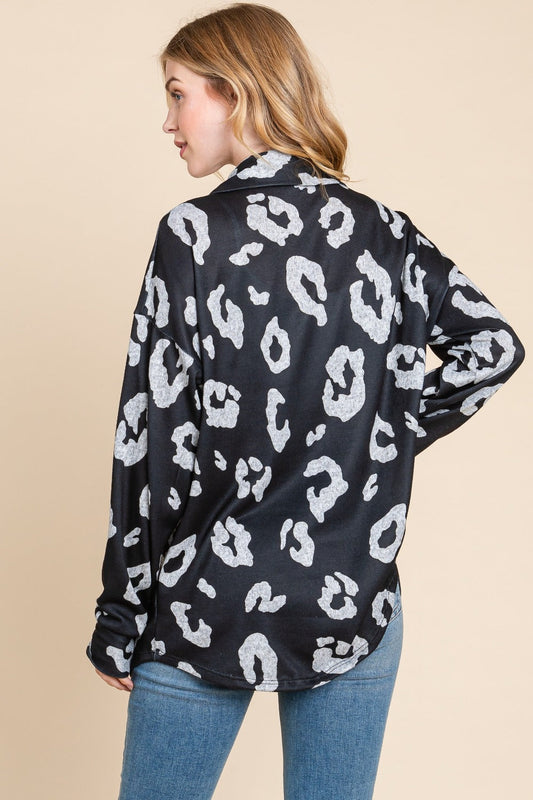 Woman wearing animal print button-up knit shacket with pockets, made of 95% polyester and 5% spandex, slightly stretchy fabric.