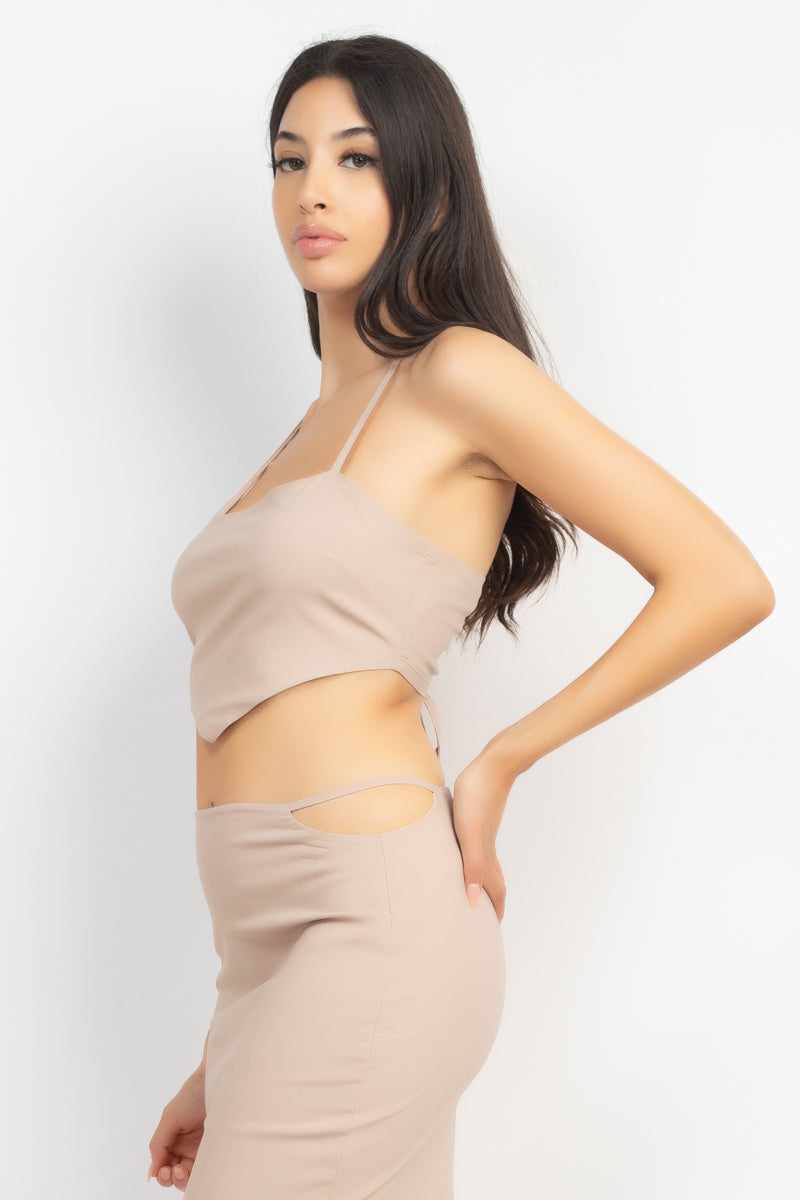 Light Taupe asymmetrical cross back top and skirt set showing a sleeveless design with high waist and side cutout features.