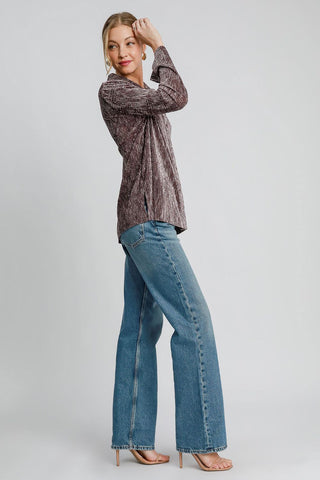 Woman wearing brown side slit textured button-up shirt with jeans, showcasing stylish casual look.