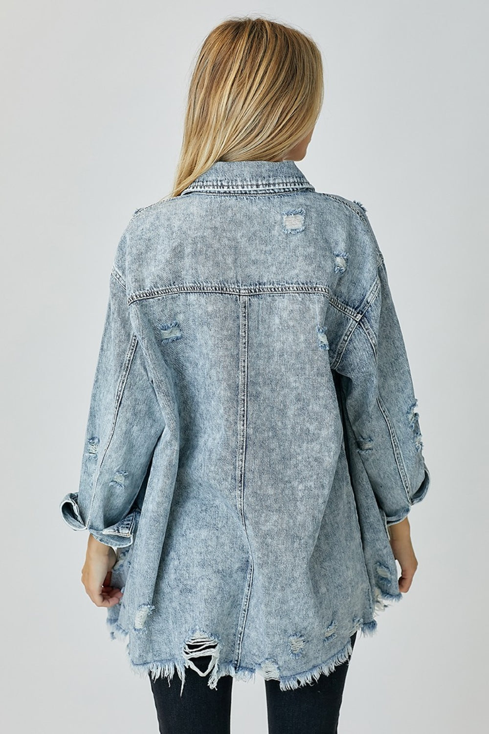 Woman wearing Bae Distressed Raw Hem Denim Shirt in washed 100% cotton, back view showing raw hem detail, no stretch.