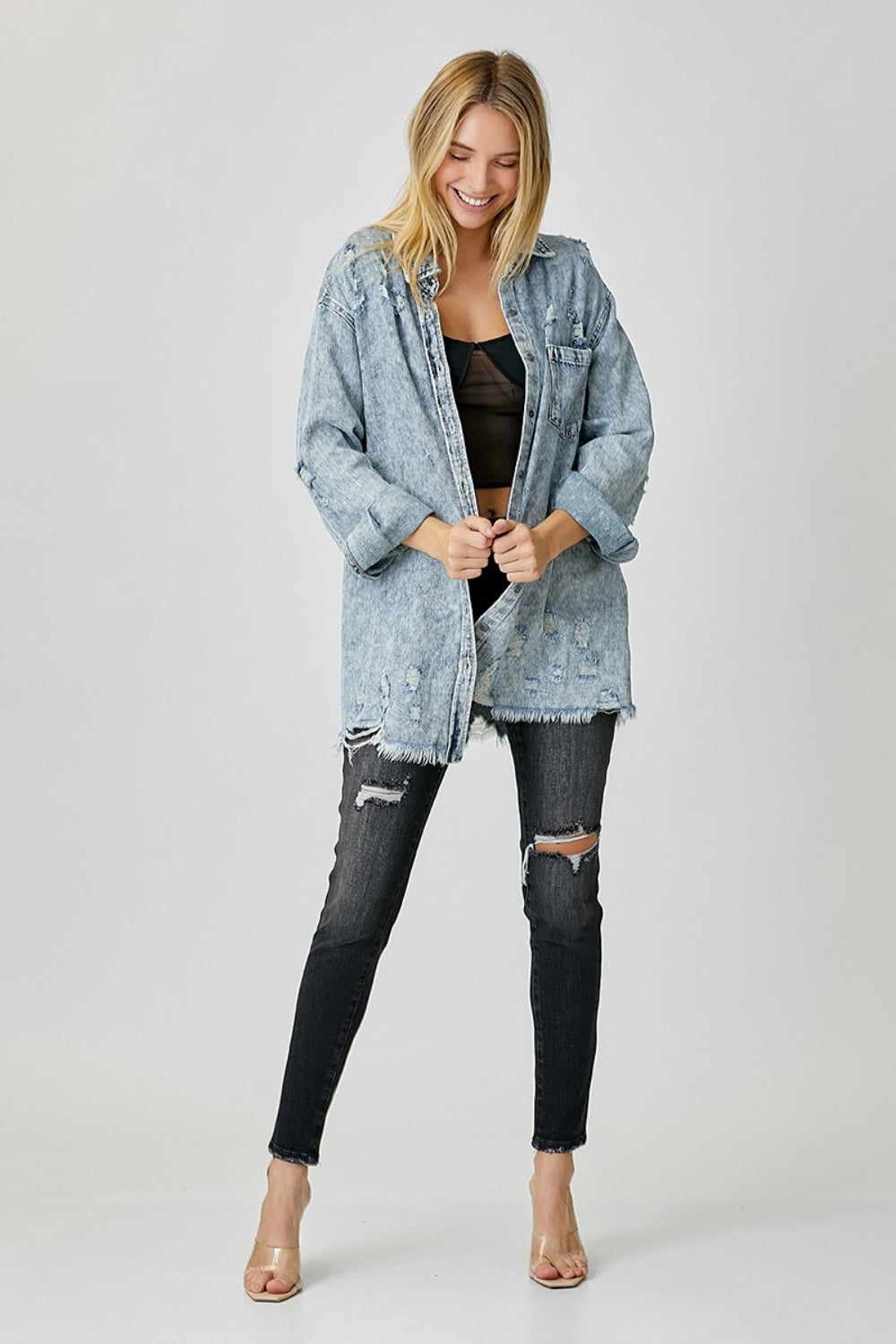 Woman wearing Bae Distressed Raw Hem Denim Shirt in washed 100% cotton with no stretch, paired with ripped jeans.